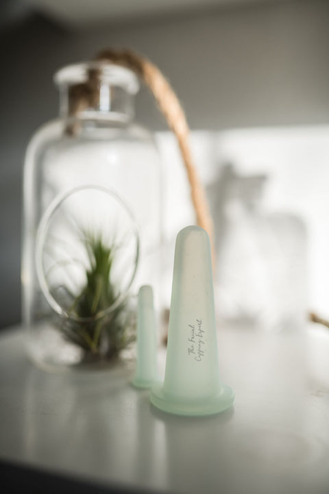 Pretty cotton drawstring bag containing 4 pale green silicon cups for facial cupping. Coming in 2 sizes with a cleaning brush they are a perfect set to improve facial muscle tone from the Facial Cupping Expert