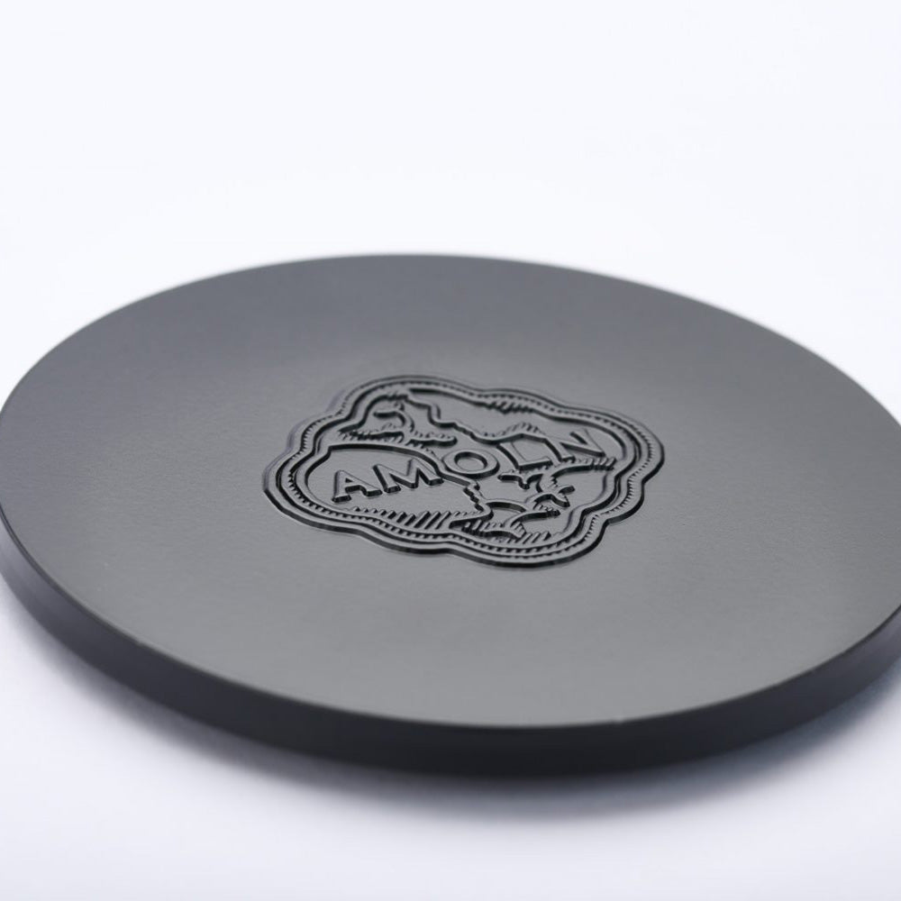 The solid black metal embossed candle lid protects Amoln’s monochromatic blue candles and preserves the scent