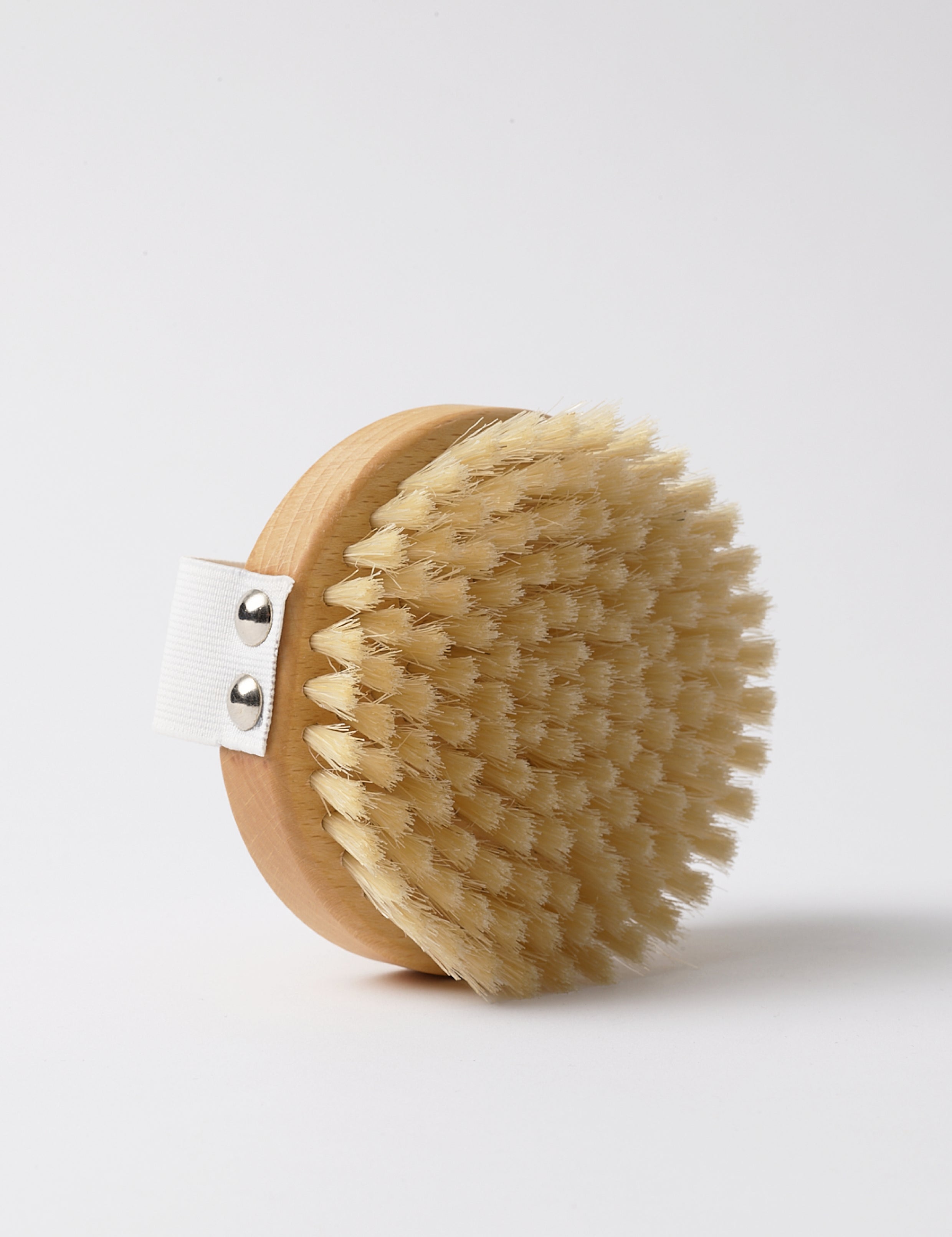 Natural wood and bristle round body brush with practical webbing for ease of use in your bodycare rituals, in a beautiful quality gift box traditionally made for Djusie.