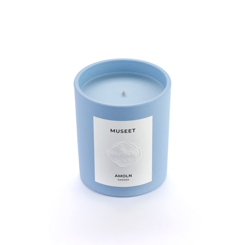 Signature blue candle in the same sky blue ceramic jar, inspired by Scandinavian skies, in the scent Museet - a blend of grapefruit, juniper, leather & violet from Amoln, makers of Sweden's royal candles.