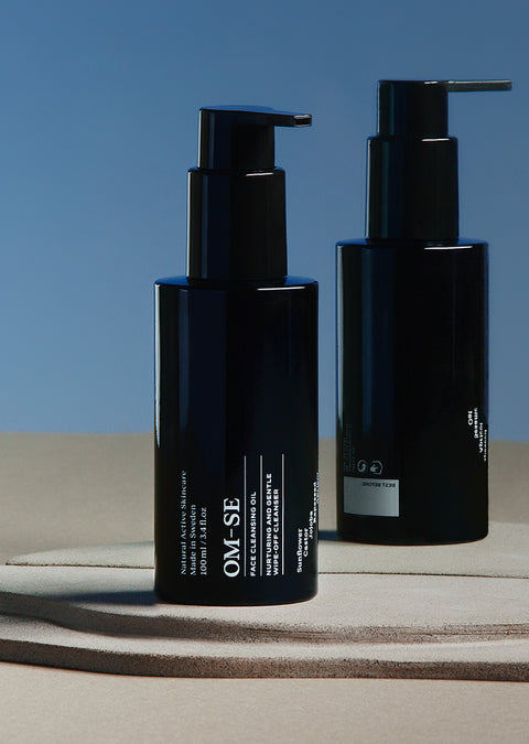 Sleek black glass bottle with stark white text, delivered in sustainable luxury white packaging creates a stylish minimalist skincare line from OM-SE. This cleansing oil is vegan and totally organic for easy beauty routines.