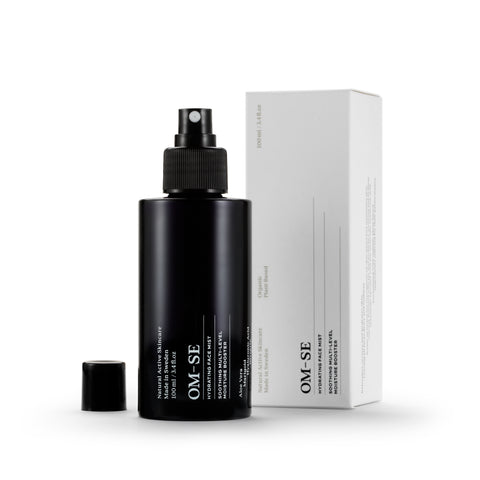 Sleek black glass bottle with stark white text in white luxury packaging creates a stylish minimalist skincare line from OM-SE. This hydrating facial mist is vegan and totally organic for easy beauty routines.