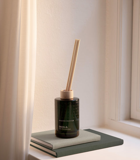 SKOG forest scent diffuser of organic vegan room fragrance with 8 sticks in dark green coloured glass jars for the best in Nordic home style from Skandinavisk