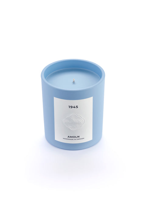 Signature blue candle in the same sky blue ceramic jar, inspired by Scandinavian skies, in the scent 1945  - a blend of citrus, florals and woods from Amoln, makers of Sweden's royal candles.