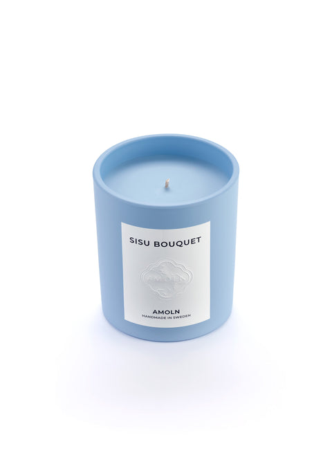 Signature blue candle in the same sky blue ceramic jar, inspired by Scandinavian skies, in the scent Sisu Bouquet - a blend of florals,  saffron, cut grass & woods & violet from Amoln, makers of Sweden's royal candles.