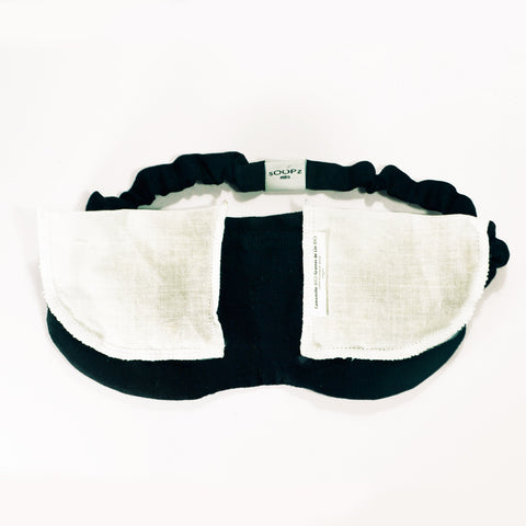 Black linen sleep mask with pockets containing organic lavender flowers or chamomile flowers for aromatherapy benefits. Soopz Paris
